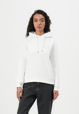 Felpa bianca con cappuccio regolabile e logo tono su tono. Tessuto morbido, polsini e orlo a coste, indossata con jeans scuri. Design pulito e semplice.