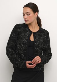 Zwarte gebreide cardigan met een gestructureerd oppervlak, voorzien van sequins, een ronde halslijn en een knoopsluiting. Slank model en lange mouwen.