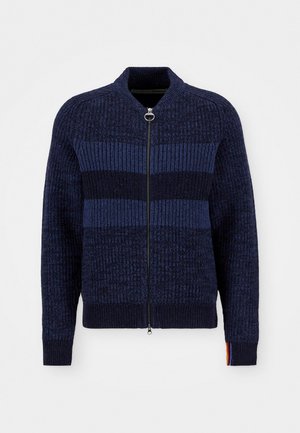 Navy knitted zip-up sweater with textured stripes, ribbed cuffs, and a stand-up collar. Features a contrast colored accent on the sleeve.