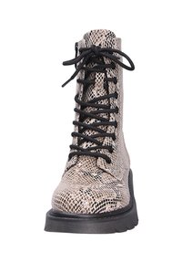 Bottine montante à lacets avec motif en serpent beige et noir, semelle noire et épais lacets noirs, vue de face.