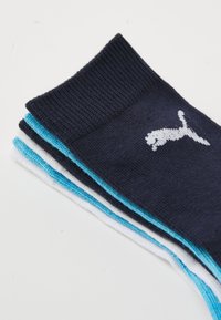 Keturių porų laivinių kojinių rinkinyje, tinkamai mėlynų, baltų ir šviesiai mėlynų spalvų; su baltu Puma logotipu; pagamintos iš medvilnės mišinio, su banguotais kraštais ir lygiu paviršiumi.