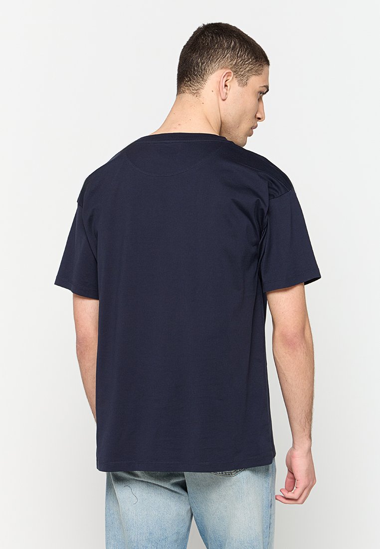 Dunkelblaues Baumwoll-T-Shirt mit lässiger Passform, kurzen Ärmeln und Rundhalsausschnitt. Glatte Textur mit einfarbigem Rücken.