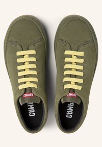 Baskets en daim vert avec lacets jaunes, bout arrondi, accents cousus et semelle intérieure noire avec branding blanc.