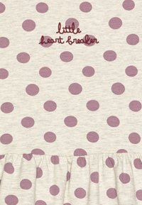 Abito in cotone beige con pois viola, caratterizzato da ricamo "little heart breaker" e orlo arricciato. Texture liscia, design informale.