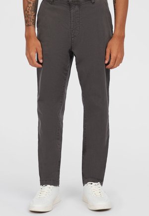 Grijze, slim-fit broek van lichtgewicht stof, met een gladde textuur en een knoopsluiting, gecombineerd met witte sneakers.