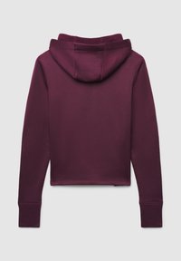 Hoodie corto color bordeaux con tasca a marsupio frontale, polsini a costine e cappuccio foderato. Texture liscia con dettagli di cucitura minimi sulle cuciture.