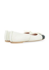 Ballerines en cuir blanc avec un bout rond noir, dotées d'une semelle en bois plate et d'un nœud décoratif à l'avant.