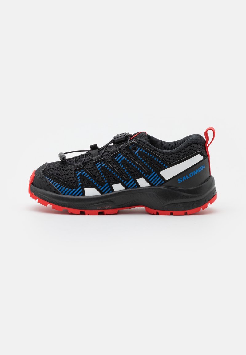Chaussure de sport noire et bleue avec une tige en maille, semelle en caoutchouc, accents rouges et système de laçage rapide. Dispose de détails antidérapants et du logo de la marque.
