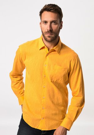 Gul skjorte med knapper i en subtil tekstur og en enkelt brystlomme. Lange ærmer, afrundede manchetter og et klassisk kravedesign.