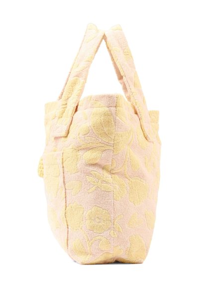 Borsa a tracolla in tessuto morbido con motivo floreale rosa pallido e giallo e due manici imbottiti, in piedi su uno sfondo bianco.