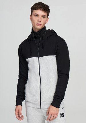 Felpa zip con cappuccio nera e grigia con colletto alto, caratterizzata da una texture liscia, cappuccio con cordino e tasche laterali.