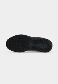 Μαύρη σόλα παπουτσιού Nike με υφασμένο μοτίβο πέλματος, που περιλαμβάνει τετράγωνα και ορθογώνια κράτη και το λογότυπο NIKE κοντά στη φτέρνα.
