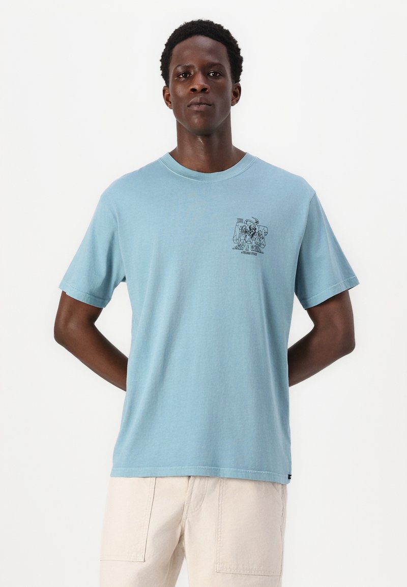 Helles blaues Baumwoll-T-Shirt mit Rundhalsausschnitt, kurzen Ärmeln und einem grafischen Druck auf der linken Brust. Weiche Textur und lässige Passform.
