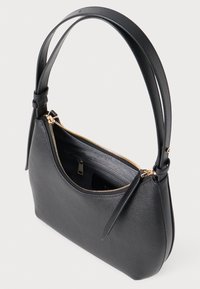 Bolsa de couro preta com formato curvado, exterior texturizado, fecho de zip e duas alças curtas. Detalhes em dourado realçam o design.