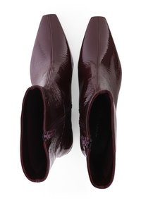 Burgunderfarbene Stiefeletten mit glänzender Oberfläche, spitzer Zehenform und seitlichen Reißverschlüssen. Sanfte Textur mit subtilen Nähdetails.