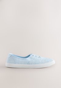 Baskets bleu clair à enfiler avec motif en dentelle florale blanche et semelle en caoutchouc blanche sur un fond neutre.