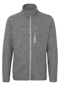 Giacca in pile grigia con alto colletto, zip completa e tasca sul petto con zip. Presenta un tessuto strutturato con motivi sottili e un tirante in pelle marrone.