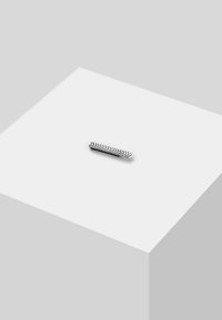 Barette metalică cu un design elegant, având un model în zigzag alb-negru. Suprafața este netedă și are un finisaj reflectant.