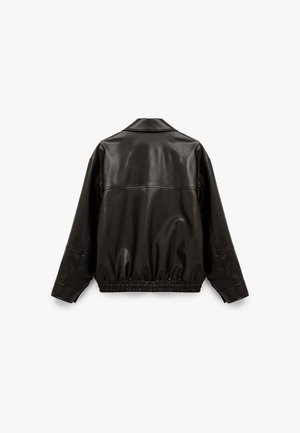 Veste noire en cuir synthétique avec une texture lisse, col montant et ourlet élastiqué. Présente des coutures apparentes et une silhouette décontractée.