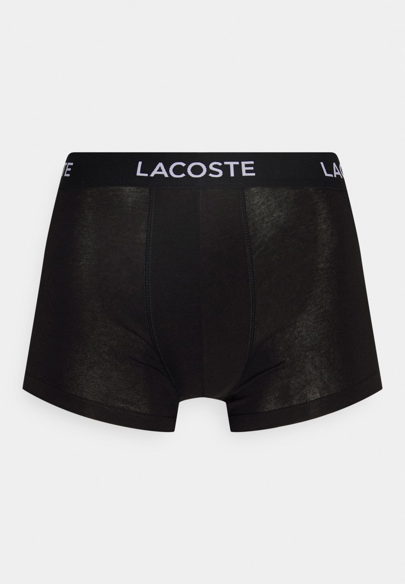 Zwarte katoenen boxer shorts met een zachte elastische tailleband waarop het "LACOSTE" logo in het wit is gedrukt. Glad materiaal met een slim fit ontwerp.