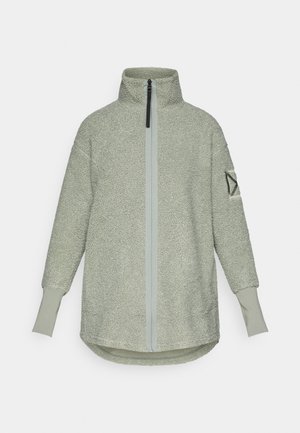 Fleece-pullover i lys grønn med høy krage, glidelås foran og ribbestrikkede mansjetter. Har en strukturert overflate og et logo-patch på ermet.