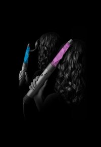 Haarstylingsysteem met een elegante grijze handgreep, voorzien van blauwe en roze barrelaccenten. Het haar is gestyled in losse krullen, weergegeven tegen een donkere achtergrond.