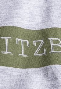 Gray fabric with a smooth texture featuring a wide green band and white block lettering spelling "ITZB". No additional patterns or accents visible.