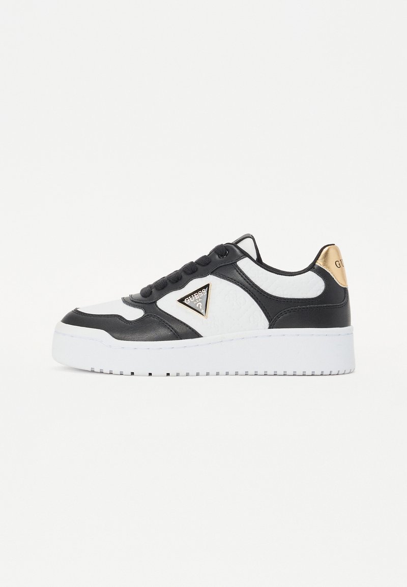 Adidași alb-negru din piele și țesătură texturată, având un logo triangular, un accent auriu pe toc și o talpă din cauciuc alb.