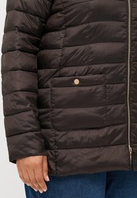 Dark brown padded jacket with quilted texture, featuring a zip closure and a snap-button pocket on the front for added detail.