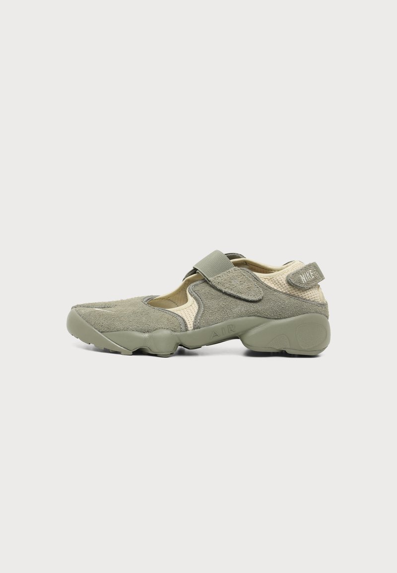 Green suede and mesh Nike sneaker with adjustable strap and visible Air sole, shown from the side on a plain background.