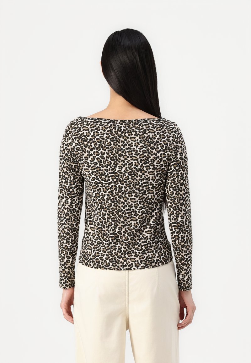 Haut à manches longues en imprimé léopard avec un large col, fabriqué en tissu doux, présentant une forme ajustée et un bord noir contrastant au niveau du cou.