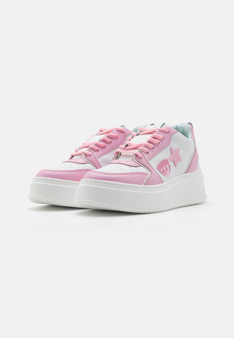 Weiße und rosa Plateausneaker mit einem oberen Teil aus glattem Leder, ausgestattet mit einem Sternakzent und rosa Schnürsenkeln, die ein abgerundetes Design aufweisen.