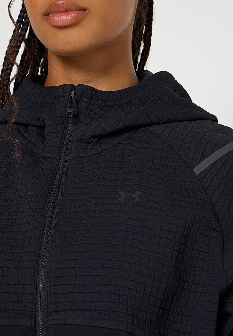 Felpa nera con texture trapuntata, chiusura con zip e logo sul petto. Presenta un cappuccio e un'accenzione riflettente sulla spalla.