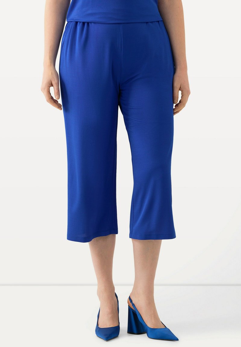 Královsky modré zkrácené kalhoty s elastickým pasem, hladkým povrchem, s uvolněným střihem a rovný řez až k lemování.