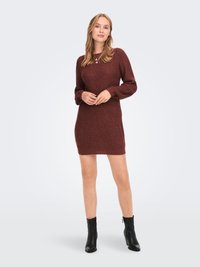 Abito a maglia bordeaux fino al ginocchio con texture a coste e lunghe maniche a sbuffo. Abbinato a stivaletti neri alla caviglia. Collo rotondo semplice.