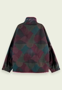 Veste colorée présentant un motif géométrique en bordeaux, vert et noir, avec des poignets élastiques et un logo sur le col. Matériau léger.