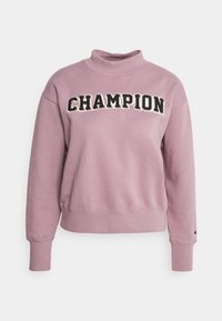 Felpa viola chiaro con colletto alto, con la scritta "CHAMPION" in lettere nere e bianche sulla parte anteriore. Polsini e fondo a coste.