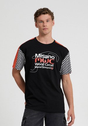 T-shirt nera in cotone con accenti rossi, maniche a quadri e il testo "Misano World Circuit Marco Simoncelli" in bianco.