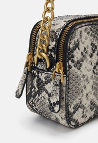 Mała prostokątna torebka z syntetycznej skóry w wężowy wzór, z złotym łańcuchem i metalowymi suwakami.