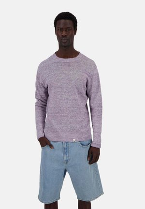 Maglione a maglia di un leggero colore viola con un motivo testurizzato, colletto rotondo e polsini a costine, abbinato a pantaloni corto di jeans in una tonalità di blu chiaro.