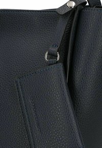 Sac à main en cuir bleu foncé avec une surface texturée, équipé d'un porte-cartes amovible, de quincaillerie en argent et de coutures bleu contrasté.