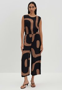 Zwarte jumpsuit met abstracte bruine vormen, mouwloos ontwerp, elastische tailleband, wijde broekspijpen, lichtgewicht stof en een relaxte pasvorm.