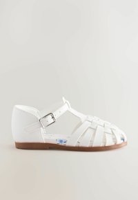 Weiße synthetische Sandalen mit geflochtenen Riemen, einem Knöchelverschluss und einer blumenbedruckten Innensohle. Flache braune Gummisohle. Geschlossene Zehenform.