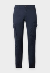 Marinblå cargobyxor med knappstängning, sidofickor och elastiska ärmslut. Tillverkade av slitstarkt tyg med en mjuk textur och rak ben-design.