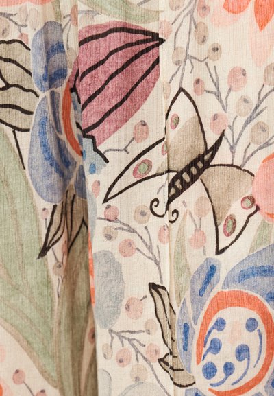Ύφασμα με πολύχρωμο σχέδιο από λουλούδια και πεταλούδες που περιλαμβάνει λεπτομέρειες σε ρόζ, μπλε, πράσινο και πορτοκαλί σε μπεζ φόντο.