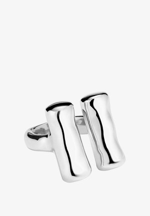 Anillo plateado elegante con un diseño asimétrico, superficies lisas y pulidas, y una banda ancha, resaltando una forma geométrica moderna.