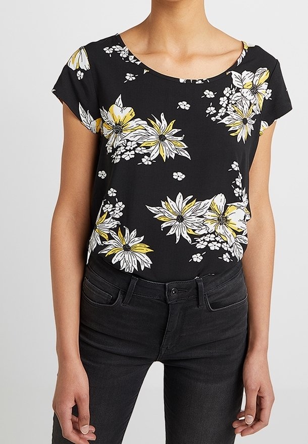 Blomstret sort top med korte ærmer; har gule og hvide blomster, en rund halsudskæring og et blødt, letstof. Sammen med sorte jeans.