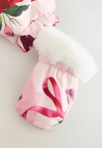 Blomsterprydede lyserøde vanter med en blød hvid pelskant, der viser et design med lyserøde bånd, hviler mod en lys grå baggrund.