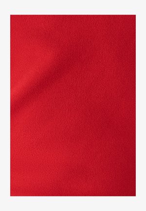 Gluda, dzīvīga sarkana auduma virsma ar mīkstu tekstūru, kurai raksturīgs vienmērīgs virsmas raksts. Nav redzamu šuvju vai aparatūras detaļu.