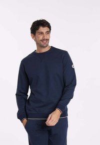 Sweat-shirt bleu marine en tissu doux, avec un col rond, de longues manches, des bords côtelés et un accent contrastant à l'ourlet.